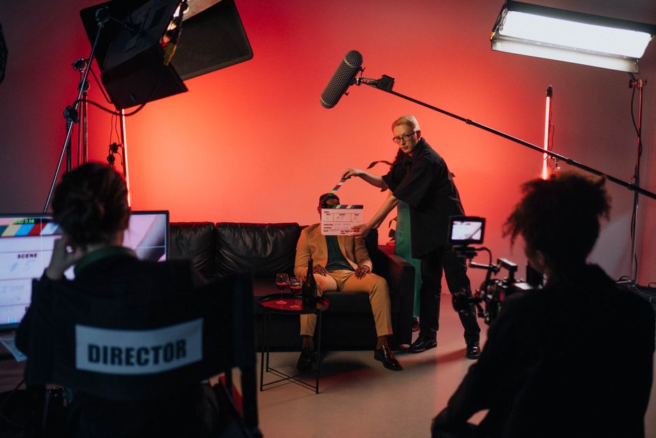 Cultura Pop — A behind-the-scenes look at a filming crew setting up a scene indoors with lighting equipment.